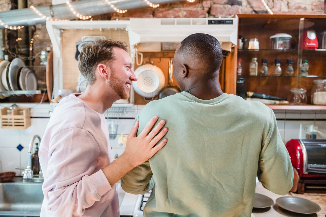A gay couple cooking together in the kitchen