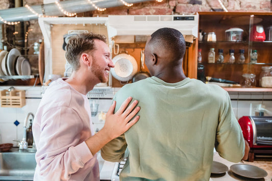 A gay couple cooking together in the kitchen