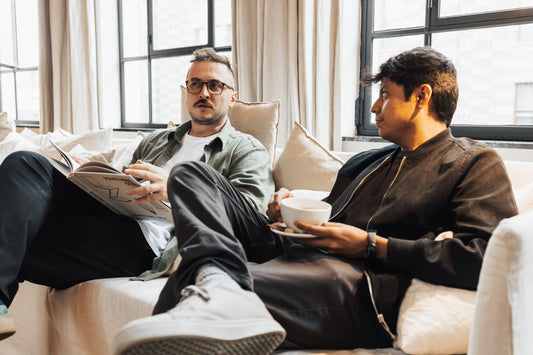Two men talking together on a sofa at home