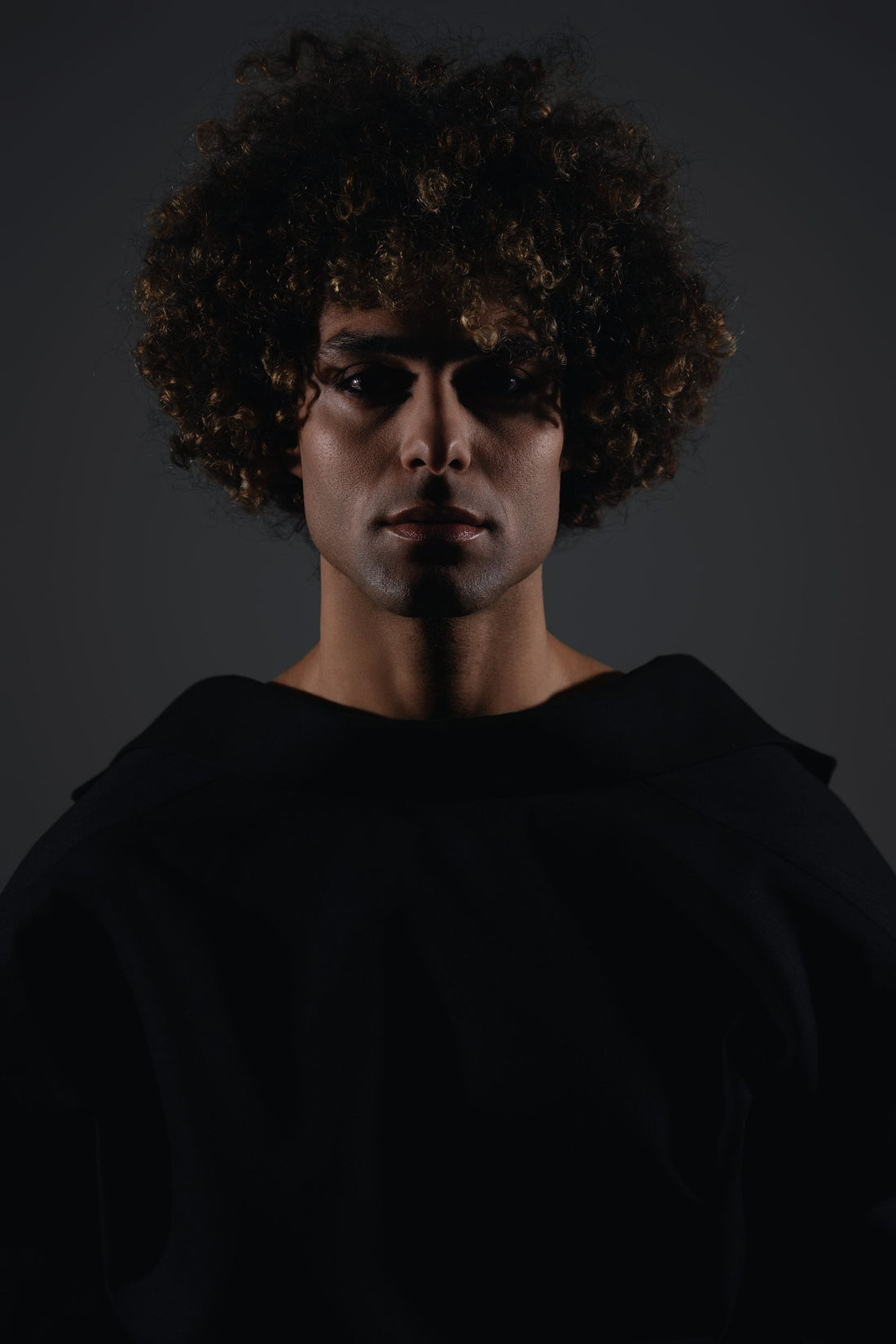 A moody, dramatic male portrait in low light