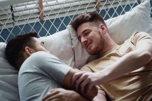Two men close together in bed